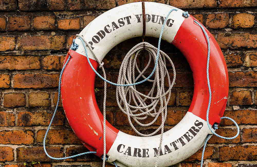 Rettungsring rot-weiß mit Aufschrift Podcast Young Care Matters an Klinkerwand mit Seil.