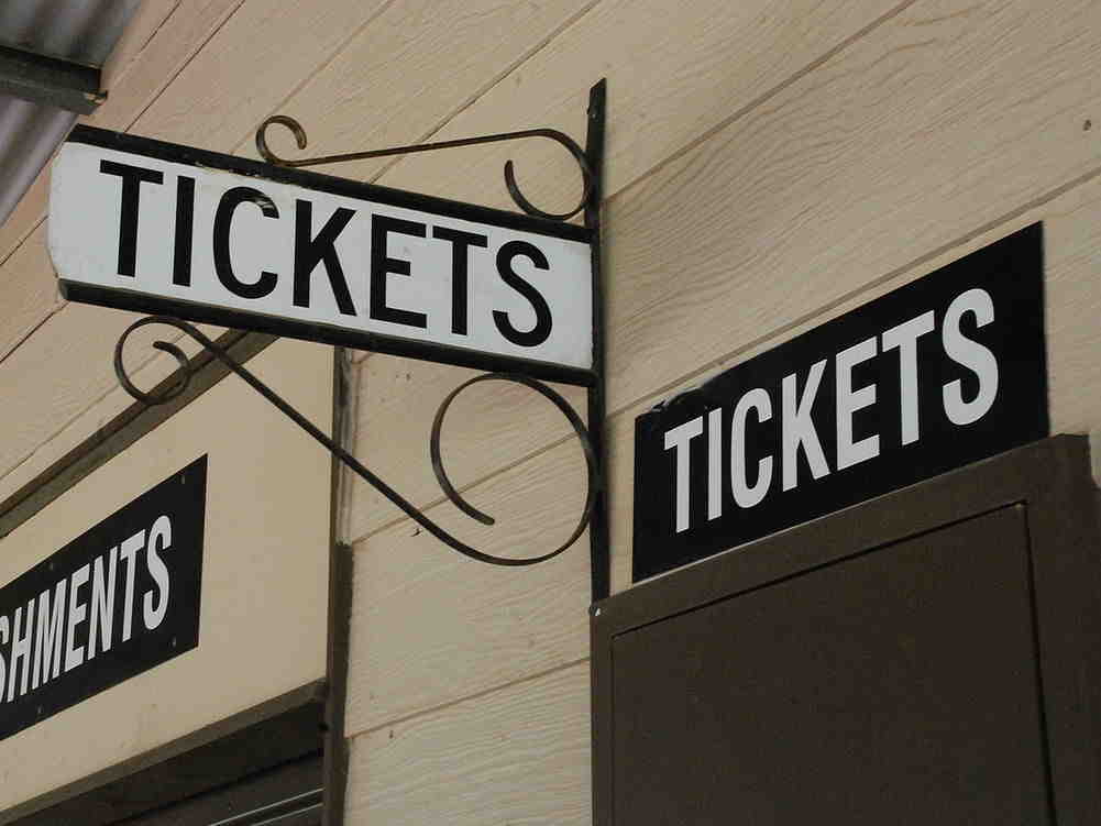 Schilder mit dem Wort Tickets an der Außenwand eines Gebäudes.