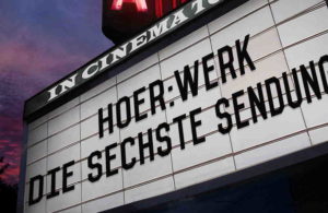Kinosaal Leuchtreklame mit Schriftzug Hoer Werk die sechste Sendung